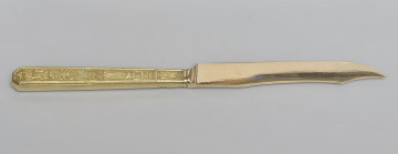 ujęcie 3/4 - strona z gładką głownią. Ujęcie z widocznym grzbietem. Czubek ostrza skierowany w prawą stronę.