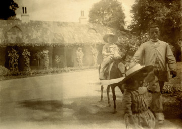 Na pierwszym planie zdjęcia widoczny jest chłopiec, za nim, na kucyku siedzi dzieczynka; kuca prowadzi pracownik ordynacji przeworskiej.