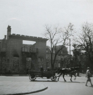 Fotografia przedstawia fragment zniszczonej na początku wojny elewacji budynku bez dachu i kolejnych kondygnacji.