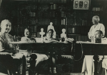 Na zdjęciu znajduje sie kilka osób siedzących przy stole.