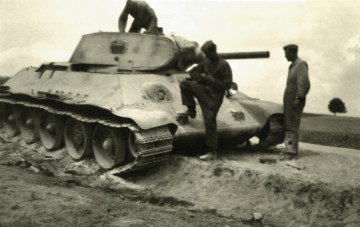Na zdjęciu znajduje się czołg oraz trzech żołnierzy. 