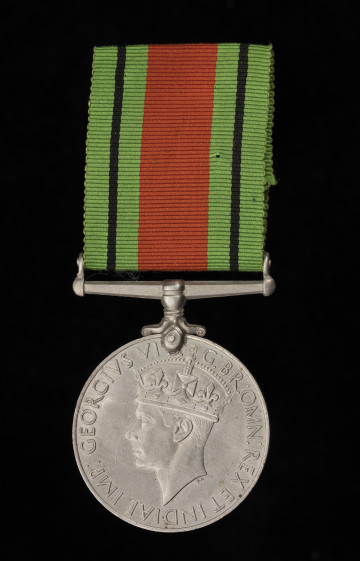 Medal Wojny 1939–1945 - ujęcie z przodu; Medal okrągły z poziomym uchwytem na wstążkę. na awersie lewy profil króla Jerzego VI w koronie. Napis w otoku majuskułą: GEORGIVS VI D: G: BR: OMN: REX ET INDIAE IMP:. Przy medalu niewłaściwa wstążka (barwy: zielono-rudo-czarna), pochodząca z medalu 