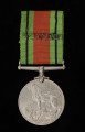 Medal Wojny 1939–1945 - ujęcie z tyłu; Medal okrągły z poziomym uchwytem na wstążkę. na rewersie lew stojący na ciele dwugłowego smoka. Nad grzbietem lwa daty 1939 / 1945. Przy medalu niewłaściwa wstążka (barwy: zielono-rudo-czarna), pochodząca z medalu 
