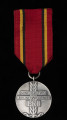 Medal za Udział w Walkach o Berlin - ujęcie z tyłu; Oznaką medalu jest wykonany z metalu srebrzonego i oksydowanego krążek, na którego rewersie jest wkomponowany poziomo na tle gałązki lauru trzywierszowy napis: 