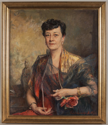 Portret kobiety w sukni wieczorowej. Na szyi sznur pereł, na ramionach szal. Na obu rękach złota bizuteria. Pod lewą ręką namalowany kwiat. Obraz sygnowany w lewym dolnym rogu
