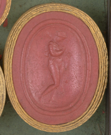 czerwona owalna gemma w grubym złotym obramowaniu; naga kobieta stojąca z opuszczoną głową, widoczna z prawego boku, kobieta ma lwią skórę zawieszoną na ramionach, a na ramieniu opiera maczugę