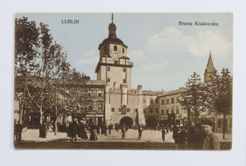 W centralnej części kartki Brama Krakowska, otynkowana, z żelazną galerią dookoła górnej kondygnacji. Po obu jej stronach przylgające dwupiętrowe kamienice, częściowo zasłonięte przez korony drzew. Na brukowanej ulicy wielu przechodniów, na pierwszym planie z prawej strony kilku mężczyzn wpatrzonych w obiektyw. Fotografia wykonana w pogodny, słoneczny dzień, pierwszy plan częściowo zacieniony. Na odwrociu informacja o autorze fotografii i wydawcy.