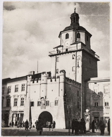 Fotografia Bramy Krakowskiej	nieznany (autor)	zdjęcie czarno-białe, Brama Krakowska, wejście do bramy przed nią chodza ludzie, widać fragment Hotelu Centralnego i sklepu z drożdżami	