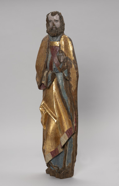 tłok pieczętny - Ujęcie ze skosu z lewej; Polichromowana i złocona figura stojącej postaci, zwróconej w trzech czwartych w prawo, przedstawia starszego mężczyznę ubranego w albę z humerałem, skrzyżowaną na piersi stułę przewiązaną paskiem cingulum oraz długą, złoconą kapę z ozdobną bordiurą i frędzlami. Prawa poła płaszcza zawinięta pod prawe ramię układa się z przodu figury po przekątnej, powierzchnią zmarszczoną w kilka fałd o wysokich grzbietach. Szeroką twarz o wysokim czole patrzącą w dal w zamyśleniu otacza gęsta fryzura półdługich włosów i rozłożystej brody. Lewa dłoń świętego unosiona na wysokości piersi, zwrócona jest wnętrzem do widza. Tył rzeźby płaski, charakterystyczny dla rzeźby przyściennej. Nos, prawa dłoń oraz palce lewej – zniszczone. Dekoracja kołeczkowa bordiury kapy zachowana szczątkowo. Podstawa rzeźby uszkodzona.
