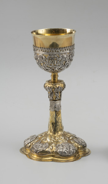 kielich mszalny - Ujęcie z przodu; Smukły kielich o sześciolistnej, wysklepionej stopie, przechodzącej w sześcioboczną, zwężającą się ku górze wysoką tuleję. Nodus sześcioboczny, wybrzuszony w górnej części, oddzielony tralkowym trzonem od czary ujętej do wysokości 2/3 ażurowym koszyczkiem.

Pola stopy zdobione naprzemiennie srebrnymi reliefowymi nakładkami z uskrzydlonymi główkami anielskimi oraz owalnymi plakietkami ze scenami Narodzin Chrystusa, Hołdu Trzech Króli i Ostatniej Wieczerzy. Wyższe partie stopy oraz tuleję pokrywa repusowany i rytowany wzór z naturalistycznych kwiatów na długich ulistnionych łodygach, zwróconych główkami w dół. Dekorację nodusa tworzy sześć wycinanych w srebrnej blasze i repusowanych srebrnych nakładek w formie pojedynczych kwiatów (tulipanów i irysa). Motywy kwiatowe w połączeniu z wicią akantową występują również w dekoracji koszyczka. Pomiędzy nie wkomponowano trzy owalne kartusze otoczone wieńcami laurowymi z hierogramami Chrystusa, Marii oraz św. Józefa.