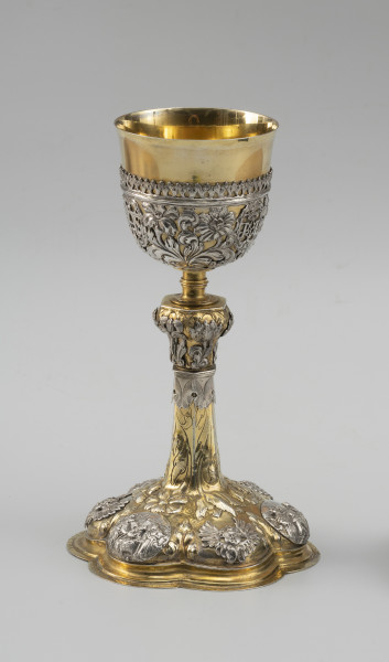 kielich mszalny - Ujęcie z przodu; Smukły kielich o sześciolistnej, wysklepionej stopie, przechodzącej w sześcioboczną, zwężającą się ku górze wysoką tuleję. Nodus sześcioboczny, wybrzuszony w górnej części, oddzielony tralkowym trzonem od czary ujętej do wysokości 2/3 ażurowym koszyczkiem.

Pola stopy zdobione naprzemiennie srebrnymi reliefowymi nakładkami z uskrzydlonymi główkami anielskimi oraz owalnymi plakietkami ze scenami Narodzin Chrystusa, Hołdu Trzech Króli i Ostatniej Wieczerzy. Wyższe partie stopy oraz tuleję pokrywa repusowany i rytowany wzór z naturalistycznych kwiatów na długich ulistnionych łodygach, zwróconych główkami w dół. Dekorację nodusa tworzy sześć wycinanych w srebrnej blasze i repusowanych srebrnych nakładek w formie pojedynczych kwiatów (tulipanów i irysa). Motywy kwiatowe w połączeniu z wicią akantową występują również w dekoracji koszyczka. Pomiędzy nie wkomponowano trzy owalne kartusze otoczone wieńcami laurowymi z hierogramami Chrystusa, Marii oraz św. Józefa.