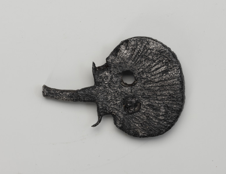 kord - detal; Tarczka w formie muszli św. Jakuba z dwoma okrągłymi otworami u dołu która mocuje się do trzonu kordu