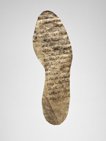 wzornik szewski - Wzornik szewski wykonany z fragmentu zwoju Tory. Kształt zbliżony do podeszwy stopy obiektu sugeruje, że to wzornik dla wkładki buta. Po stronie recto widoczny fragment tekstu w j. hebrajskim. Tekst zajmuje około 3/4 powierzchni obiektu. Strona verso bez napisów.