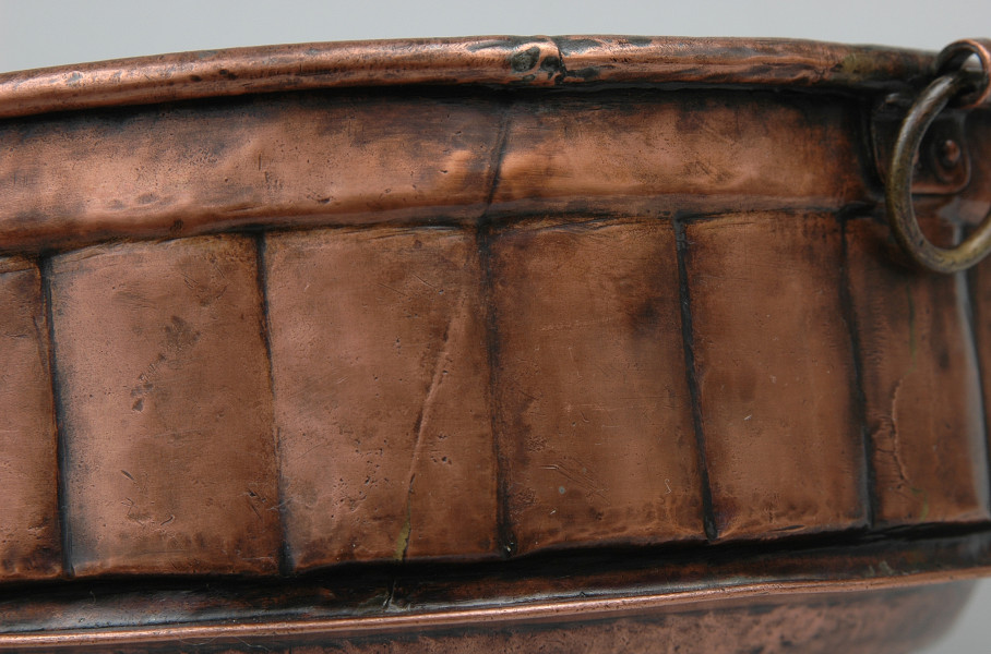 zbliżenie na ściankę naczynia (modelowaną w grube pukle) i kółko do powieszenia. Ujęcie wnętrzem do góry.