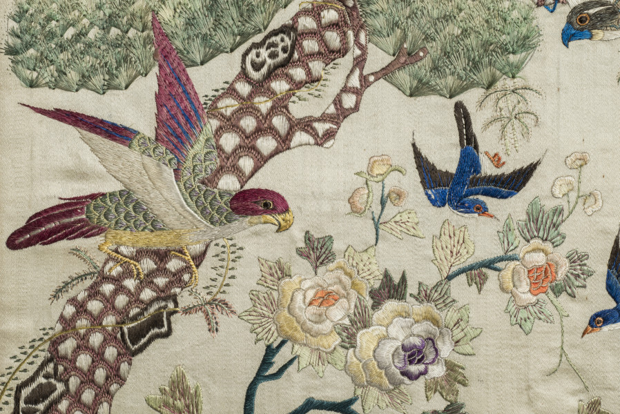 Na jedwabiu haftowana papuga siedząca na gałęzi sosny. Oraz kwitnące peonie.
