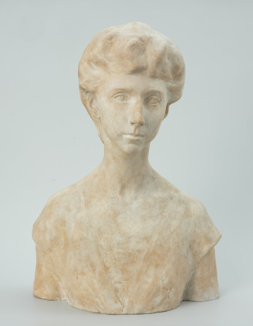 popiersie - Ujęcie z przodu; Portret młodej kobiety w popiersiu o szczupłych ramionach, długiej smukłej szyi z głową przechyloną lekko i nieznacznie skręconą w kierunku lewego ramienia. Twarz szczupła, owalna z lekko wydłużoną brodą, wydatnym podłużnym, lekko garbatym cienkim nosie, dużych migdałowych, marzycielsko rozwartych oczach, włosy odsłaniające uszy kunsztownie upięte w węzeł z tyłu głowy. Prosto wycięty dekolt lekkiej sukni odsłania kark i szyję, z przodu szpic dekoltu między piersiami wypełnia koronka.