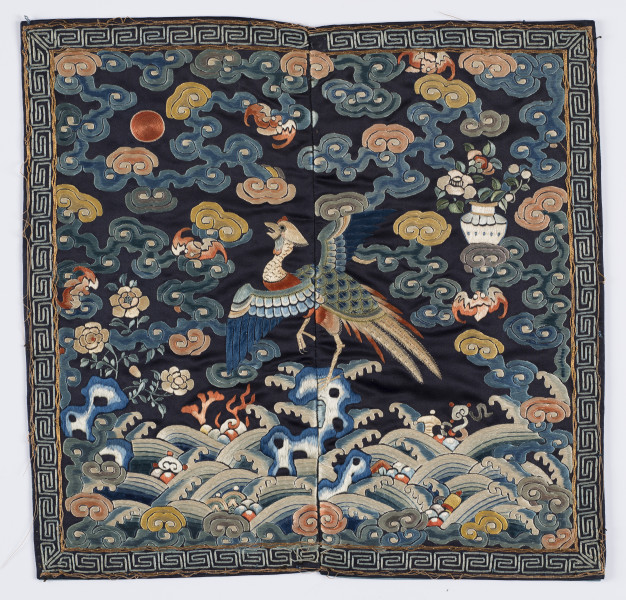 Na kwadracie jedwabiu wyhaftowany bażant z rozpostartymi skrzydłami. Wokół chmury. U dołu fale.