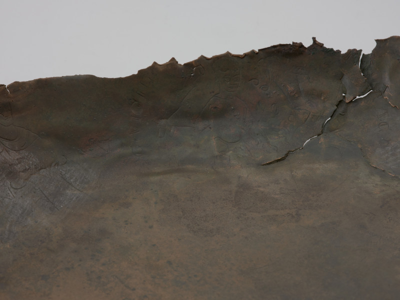 misa z rytem i tekstem - fragment misy; Misa wykonana została ze stopu miedzi, z wąskim, wywiniętym, lekko pogrubionym brzegiem i płaskim dnem. Wewnętrzną powierzchnię ścianki zdobią cztery medaliony ze scenami z życia Heraklesa, otoczone łacińskimi inskrypcjami będącymi cytatami z eklogi przypisywanej Theodolusowi, które zapisano majuskułą romańską. Medaliony przedzielono wizerunkami koronowanych głów męskich.