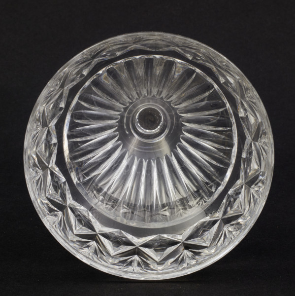 Kieliszek okrągły, ozdobiono szlifowaną dekoracją rośliną. Stopa okrągła, nóżka krótka i szeroka, zakończona pierścieniem, na którym osadzona stożkowata czara. Spód stopy dekorowany płytkim szlifem o motywie wielopłatkowego kwiatka.